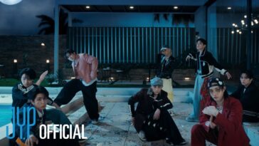 Sete membros do Stray Kids posam em um ambiente noturno, cercados por luzes e decoração vibrante.