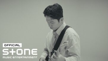 Paulkyte toca guitarra em um cenário minimalista, com expressão concentrada durante a gravação do live clip.