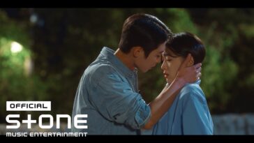 Casal se aproxima em um momento íntimo sob a luz suave, expressando emoções profundas.