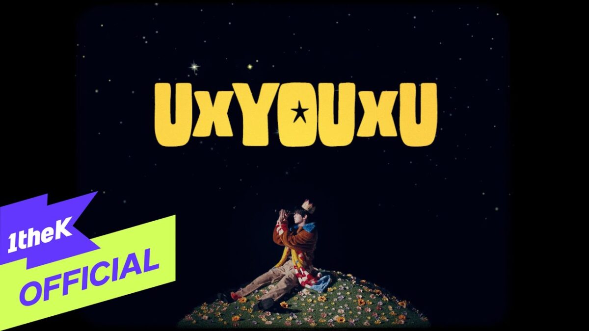 Um jovem sentado em um campo florido observa o céu estrelado com uma expressão sonhadora, ao fundo a palavra "UxYOUxU".