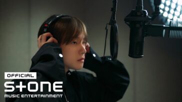 Kim Jinhwan ajusta os fones de ouvido enquanto se prepara para gravar em um estúdio de música.