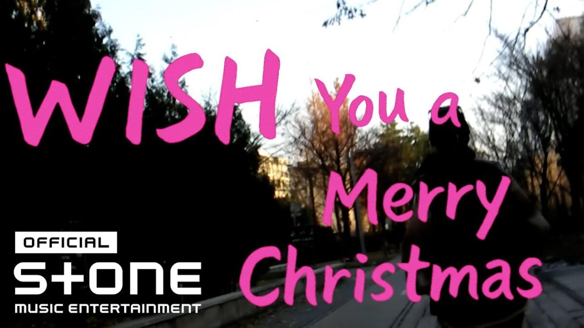 Texto colorido "WISH You a Merry Christmas" sobre uma cena de caminhada em um parque.