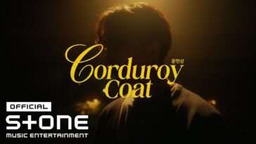 Yoon Hyun Sang usa um casaco de cotelê durante sua apresentação ao vivo, em destaque sob luz suave.