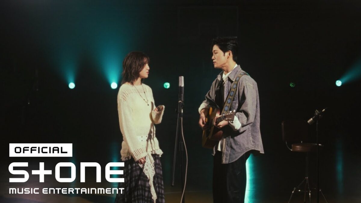 KyoungSeo e Joosiq cantam juntos em um estúdio, com microfone e violão, sob luzes suaves.