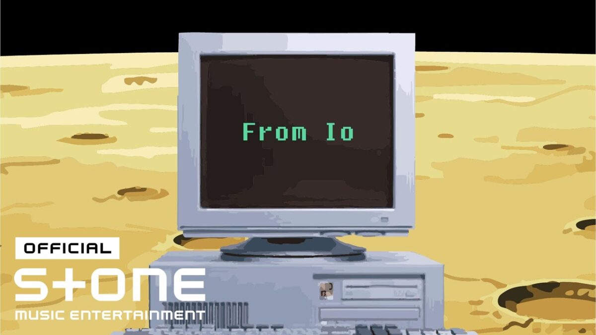 Computador antigo com tela preta exibindo "From Io" em verde, sobre um fundo amarelo lunar.