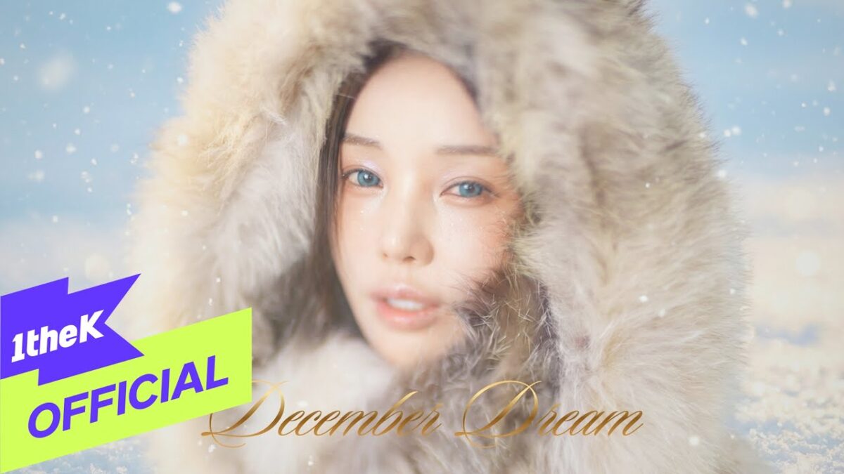 Cantora Nam Gyu Ri com capuz de pele, fundo nevado e olhar sonhador, destacando a atmosfera do videoclipe.