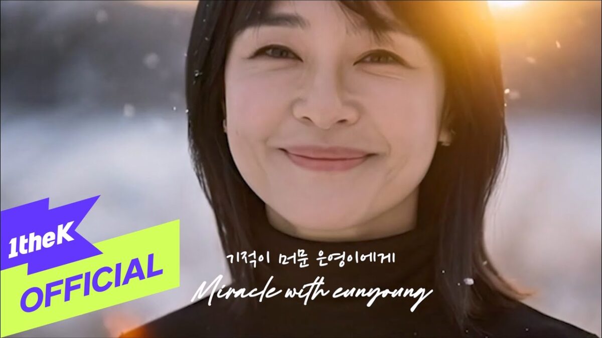 Mulher sorridente em ambiente com neve, iluminada pelo sol, com texto "Miracle with Eunyoung" na parte inferior.