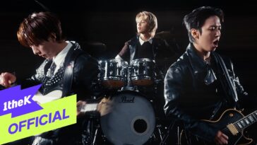 Três integrantes da banda CNBLUE tocam instrumentos em um clipe dinâmico e energético.