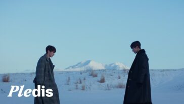 Dokyeom e Seungkwan em um campo nevado, com montanhas ao fundo, ambos com expressões pensativas.