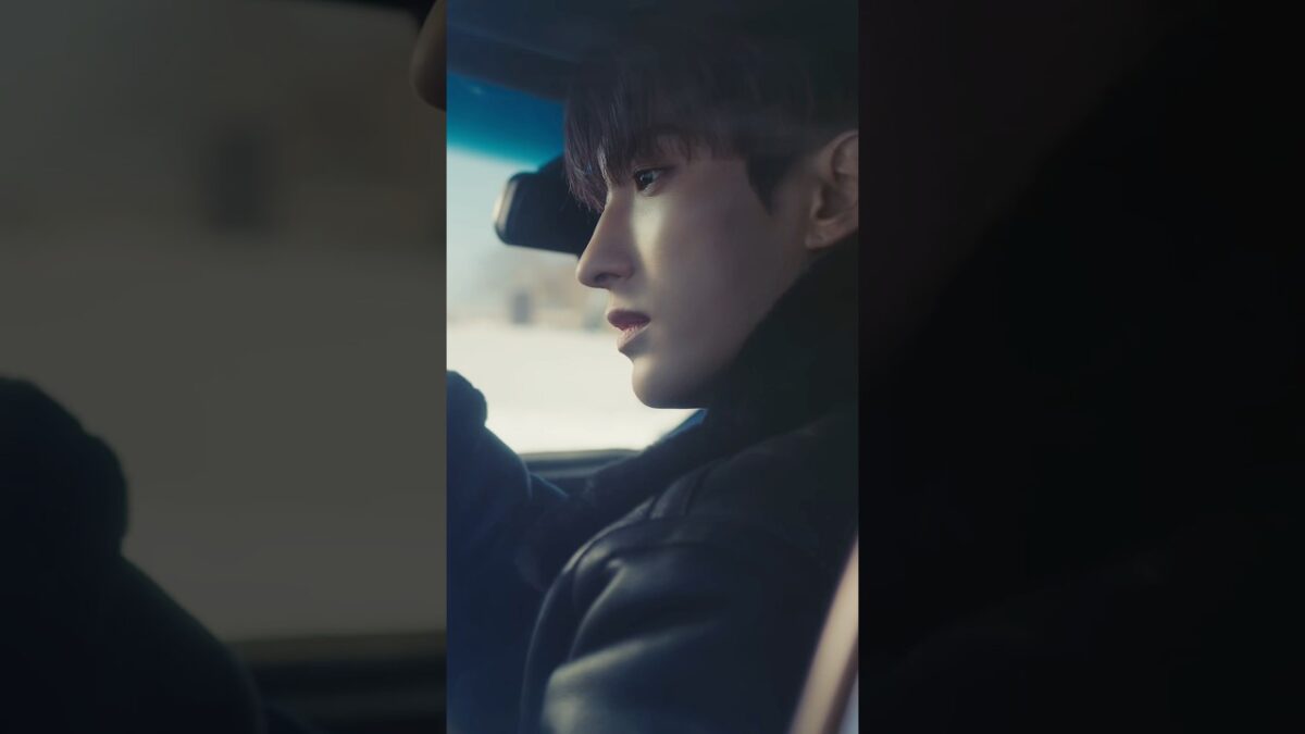 Dokyeom do SEVENTEEN em close, olhando pela janela de um carro, com iluminação suave e expressão pensativa.