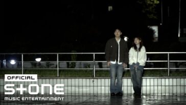 Casal em uma calçada à noite, rodeado por luzes suaves, transmitindo uma atmosfera de introspecção.