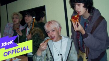 Quatro jovens se divertem em um ambiente interno, comendo pizza e segurando instrumentos musicais.