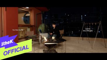 Yoo Hwe Seung sentado em uma varanda à noite, com uma mesa, fogo e decoração urbana ao fundo.
