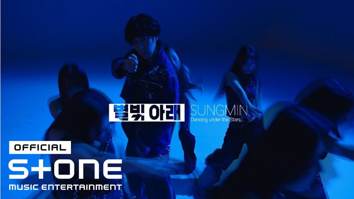SUNGMIN se destaca em uma coreografia envolvente, rodeado por dançarinos sob luzes azuis.