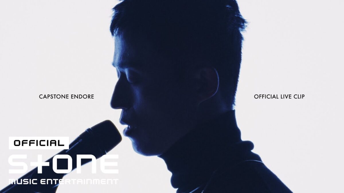 Cantor em silhueta, segurando microfone, com fundo claro e texto "Capstone Endore" e "Official Live Clip".