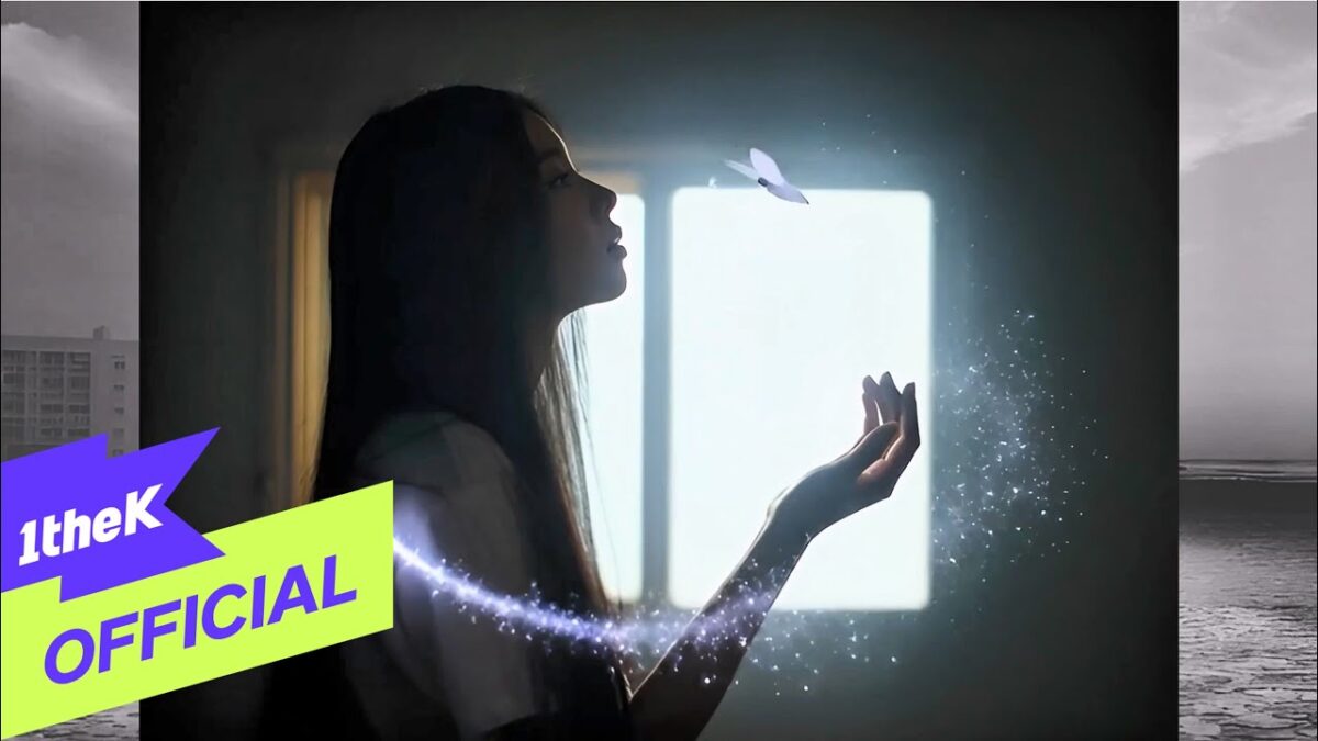 Uma jovem em perfil, com a mão estendida, observa uma borboleta flutuando em um ambiente iluminado.