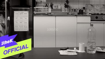 Cozinha minimalista com calendário na geladeira e objetos de uso diário sobre a mesa.