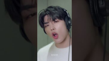 Seok Matthew canta animadamente em estúdio, usando fones de ouvido e com expressão intensa.