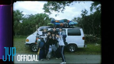 Sete jovens posam alegres em frente a uma van branca, com mochilas e equipamentos de camping no teto.