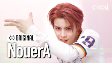 Artista com cabelo rosa e expressão intensa, executando uma dança em performance 4K.