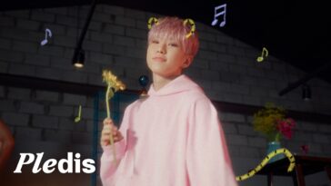 Hoshi sorri enquanto segura uma flor, com notas musicais flutuando ao seu redor em um ambiente colorido.
