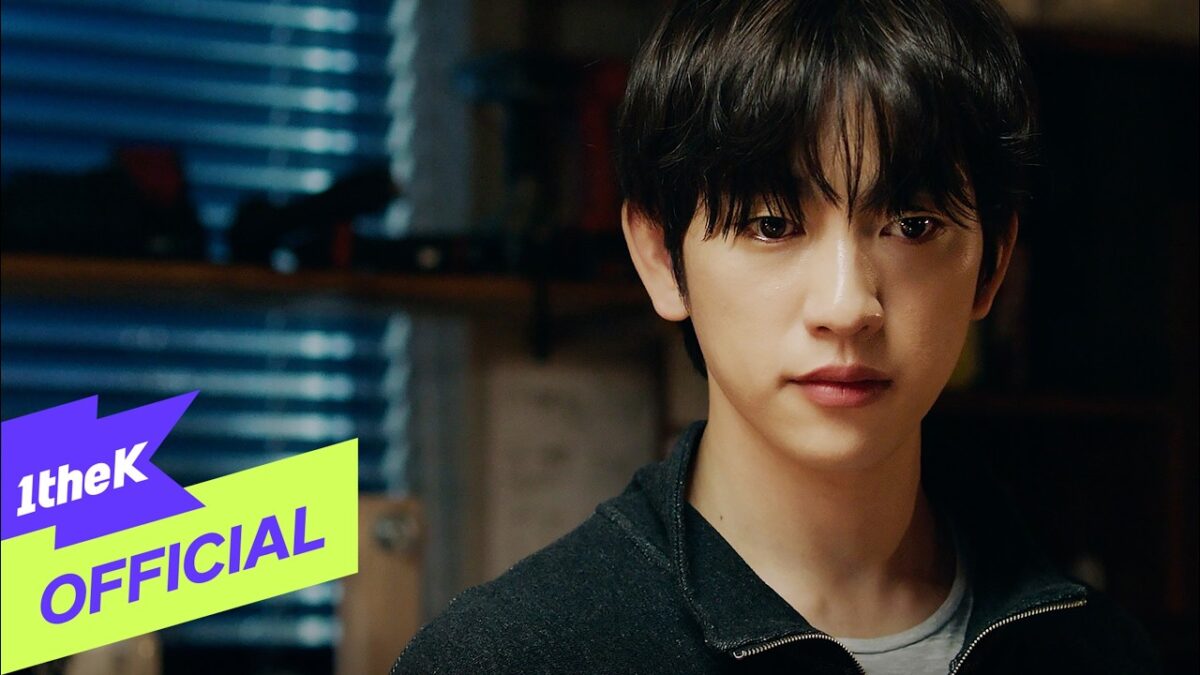 Soobin, com expressão reflexiva, está em um ambiente iluminado por luz natural, vestindo um suéter escuro.