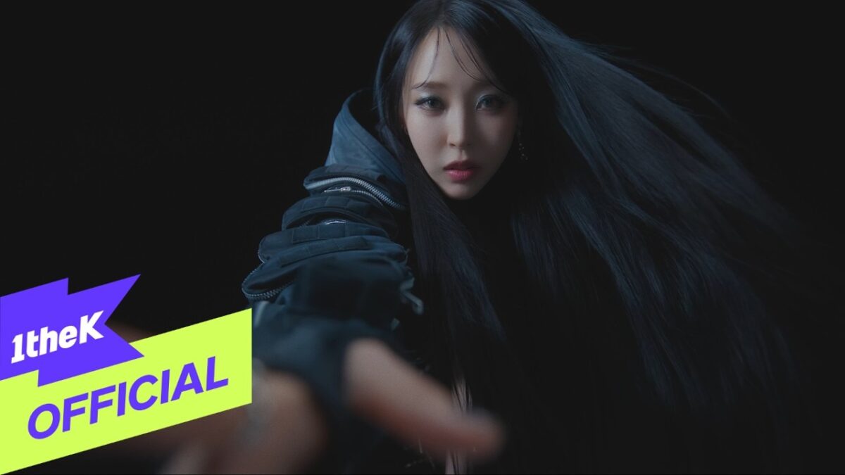 Moon Byul com cabelo longo e preto, estendendo a mão em um cenário escuro, transmitindo uma atmosfera intensa.
