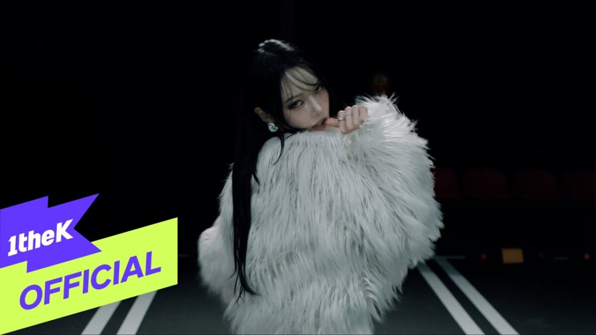 Jeon Somin veste um casaco de pele branca e olha para a câmera em um cenário escuro.