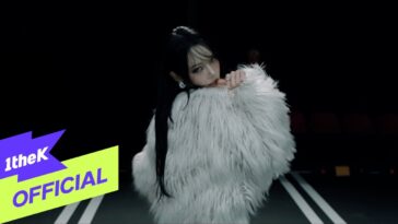 Jeon Somin veste um casaco de pele branca e olha para a câmera em um cenário escuro.