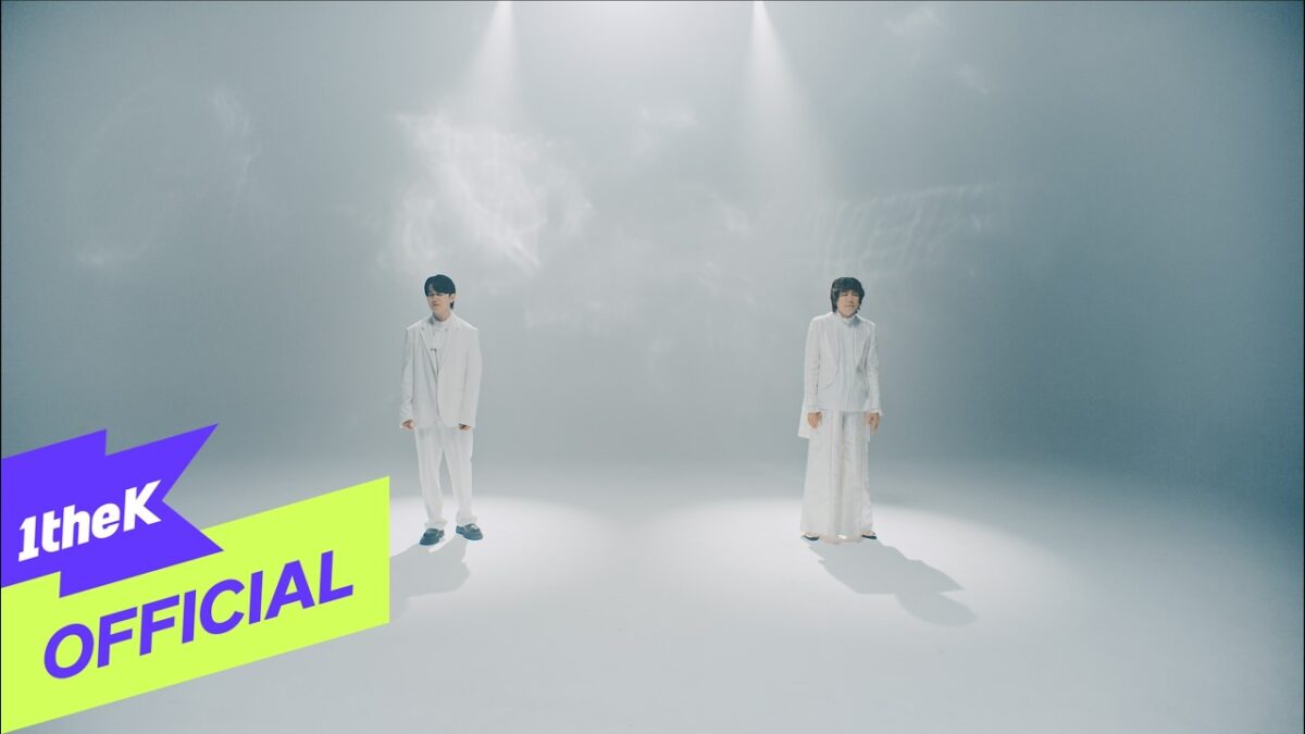 Kang Kyun Sung e Kim Jang Hoon em um cenário minimalista, ambos vestidos de branco, em destaque sob luz suave.