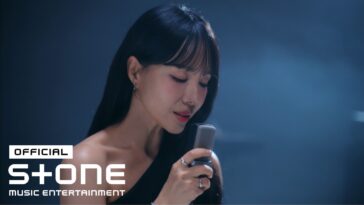 Cantora Lim Jeong Hee segura um microfone enquanto canta, com luz suave ao fundo.