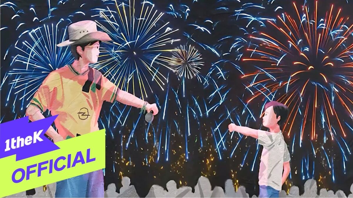 Um adulto e uma criança se divertem juntos sob um céu iluminado por fogos de artifício coloridos.