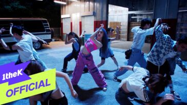 Lee Chae Yeon dança energicamente com um grupo em um cenário urbano iluminado.