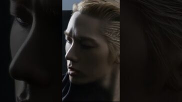 Close-up de um jovem com cabelo loiro, expressão intensa, em um fundo escuro e iluminado de forma dramática.