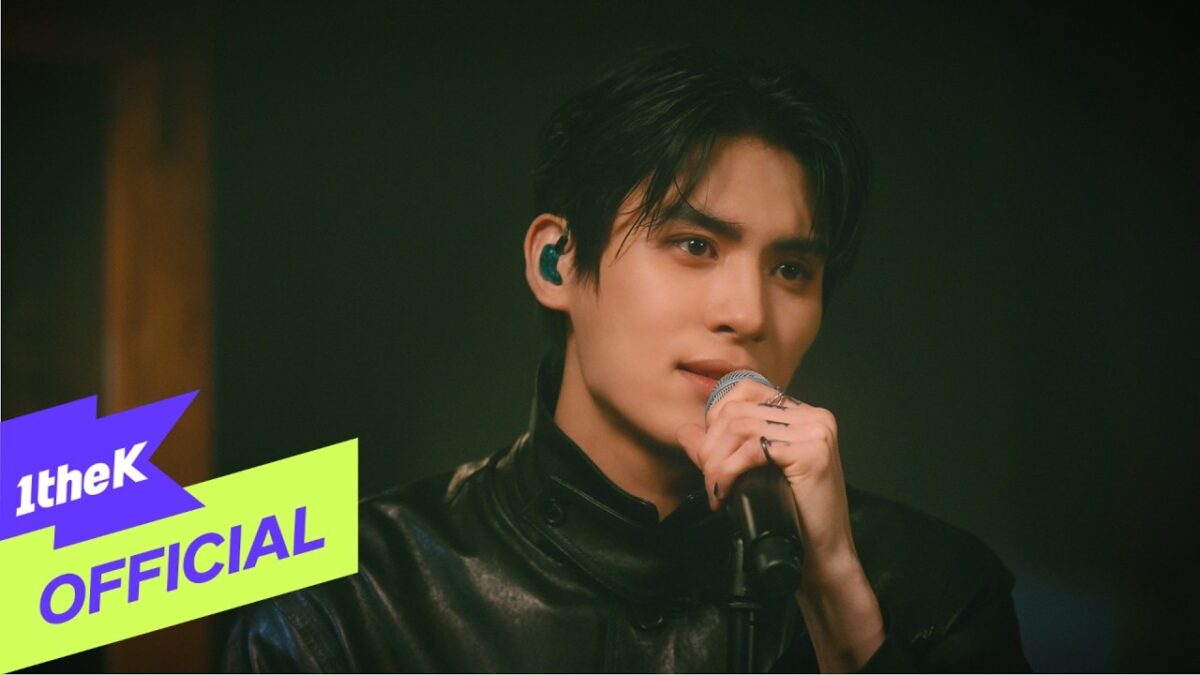 Cantor do SF9 em performance ao vivo, segurando o microfone e expressando emoção com olhar intenso.