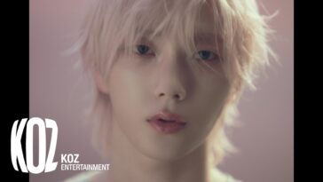 Jovem com cabelo platinado e olhar intenso, em fundo suave e desfocado, promovendo o videoclipe "Viral".