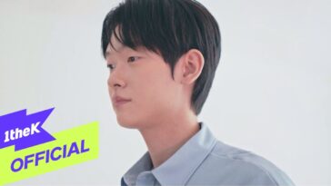 Jovem com cabelo escuro e camisa azul olha para o lado em fundo claro, com logo "1theK" no canto inferior esquerdo.