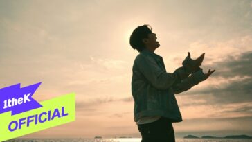 Homem em silhueta canta ao pôr do sol, com o mar ao fundo e nuvens no céu. Logo "1theK" aparece no canto inferior.