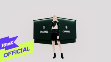 Uma jovem posando em frente a um painel preto com a palavra "CHANNEL" em destaque, vestindo um look estiloso.