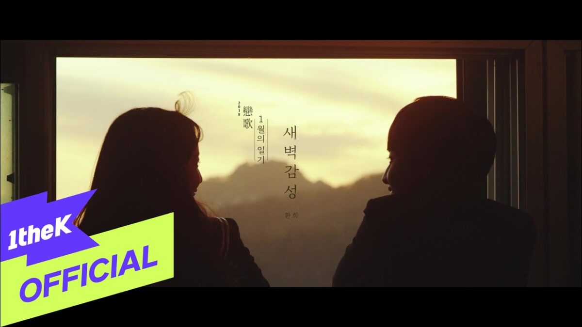 Casal observa o pôr do sol através de uma janela, criando um momento íntimo e emocional.