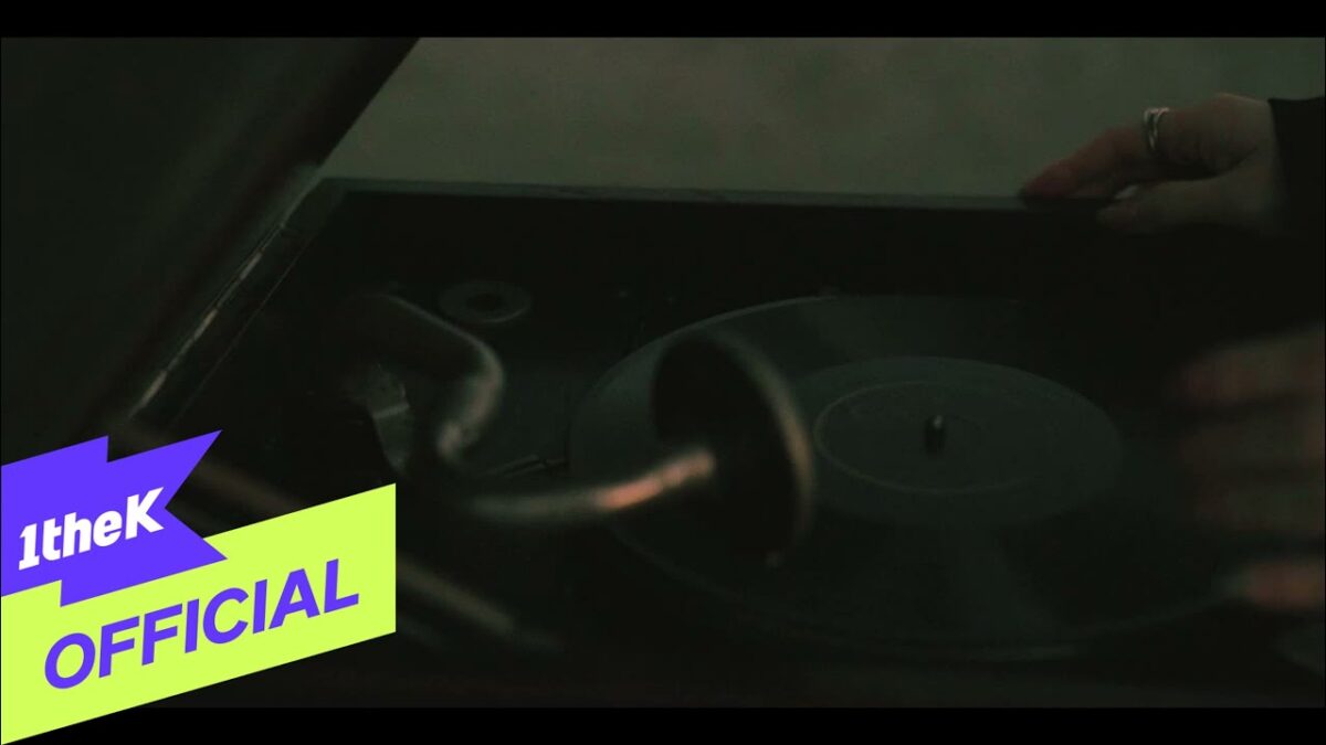 Um braço coloca um disco em um toca-discos, criando uma atmosfera nostálgica e musical.