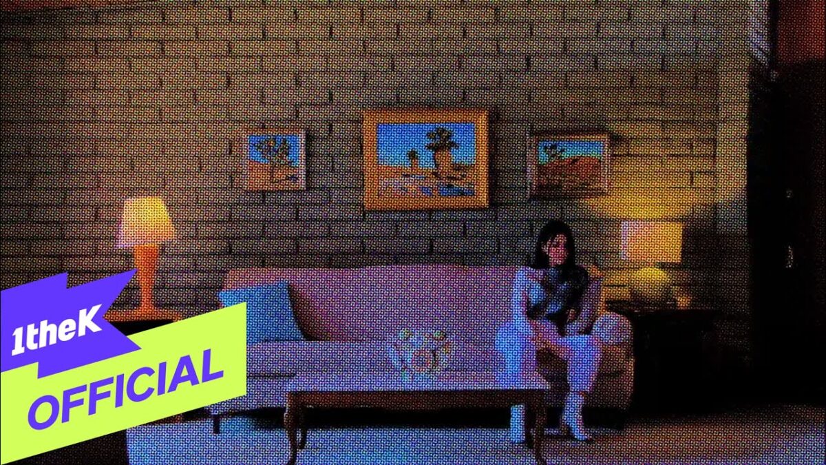 Moon Sujin sentada em um sofá em uma sala decorada com quadros e iluminação suave, promovendo a música "MILLION".