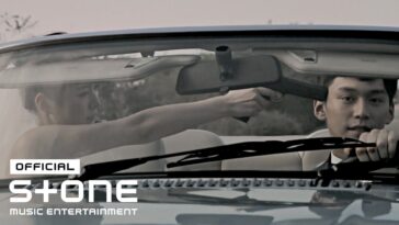 Uma mulher aponta uma arma para um homem dentro de um carro conversível.