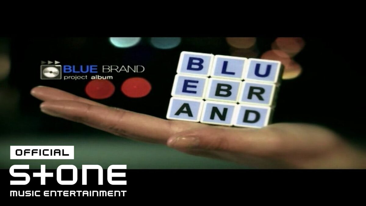 Uma mão segura blocos de letras formando a palavra "BLUE BRAND" em um fundo escuro.