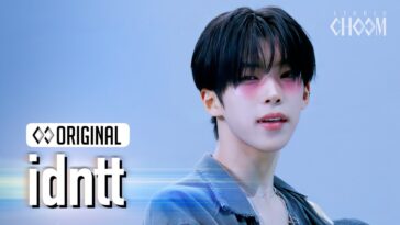 Jovem com cabelo preto e maquiagem suave, sorrindo em um fundo azul claro, com logotipo "idntt" ao lado.